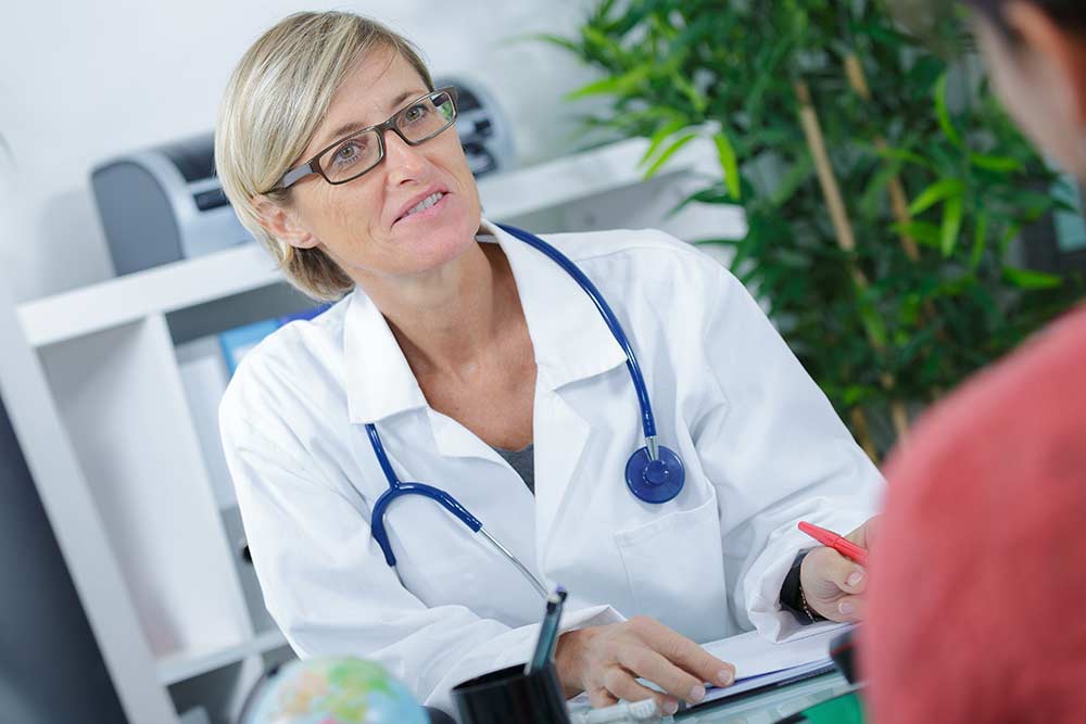 vrouwelijke arts in gesprek met patiënt