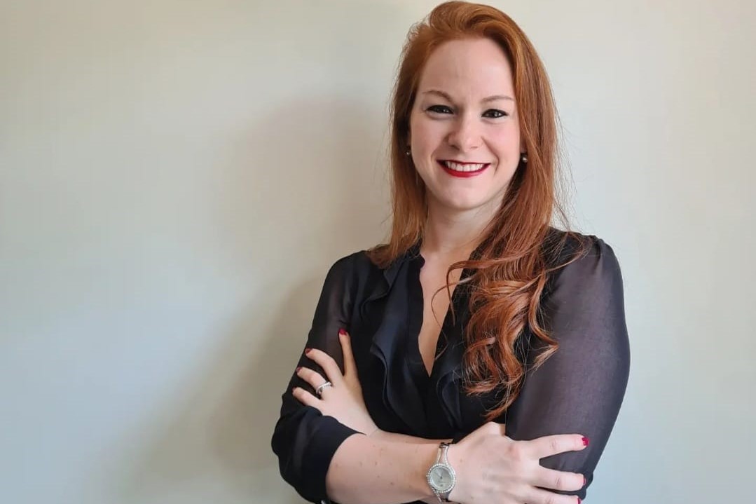 Dr. Karlijn Hermans Karlijn Hermans, een witte vrouw met rood lang haar, staat glimlachend voor een witte achtergrond. Ze draagt een zwarte blouse en heeft haar armen over elkaar heen geslagen.